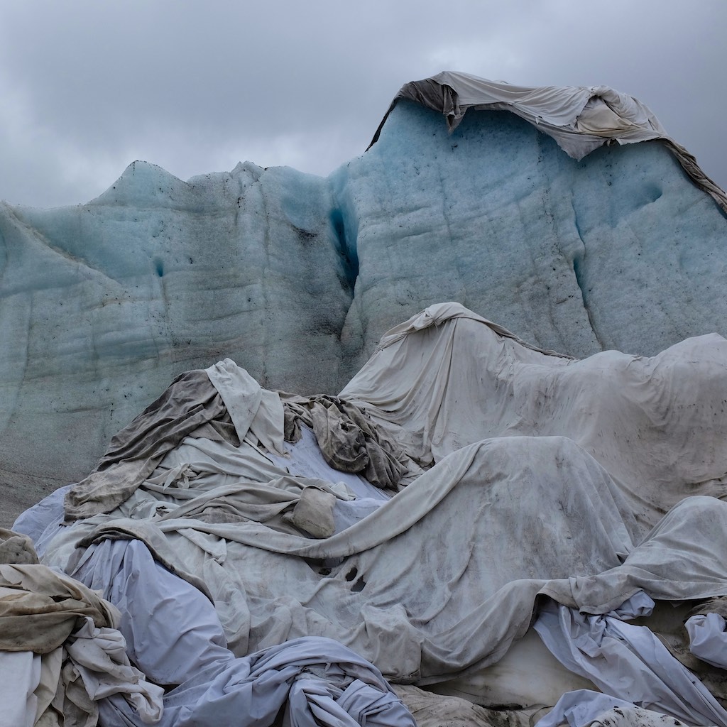 In an attempt to stall the melting of their tourist attraction, the proprietors of the Rhone Glacier ice tunnel have covered parts of the glacier in white sheets to reflect the sun.